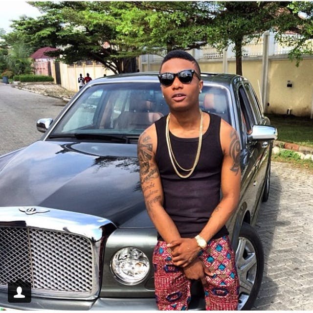 Wizkid posses with one of his cars
